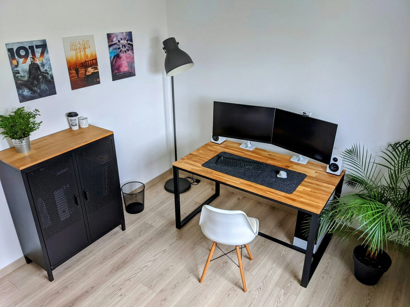 Minimal desk setup with computer, plant, lamp, and warm wood details.